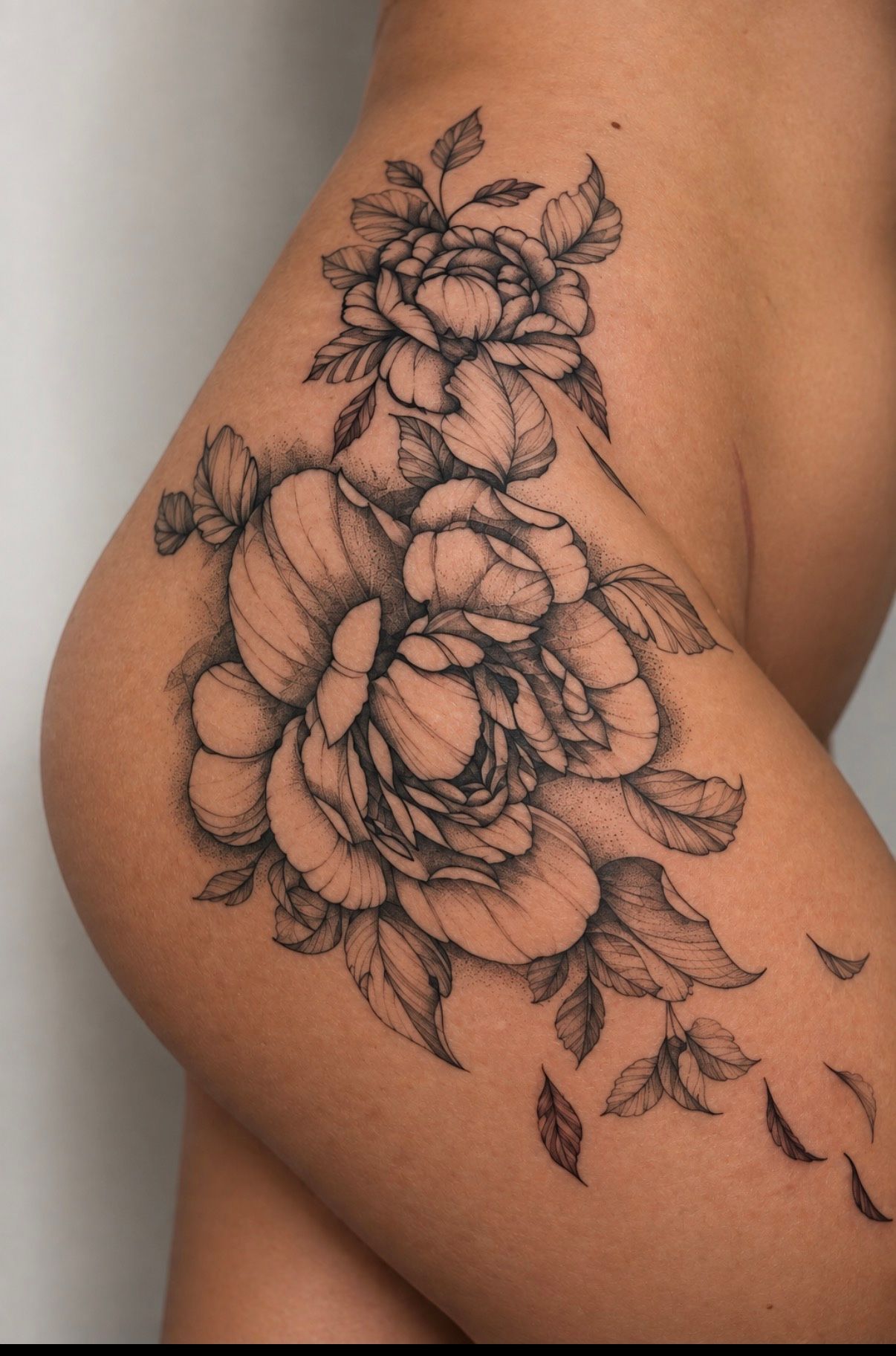 Black and grey peonies with falling petals on the hip and thigh